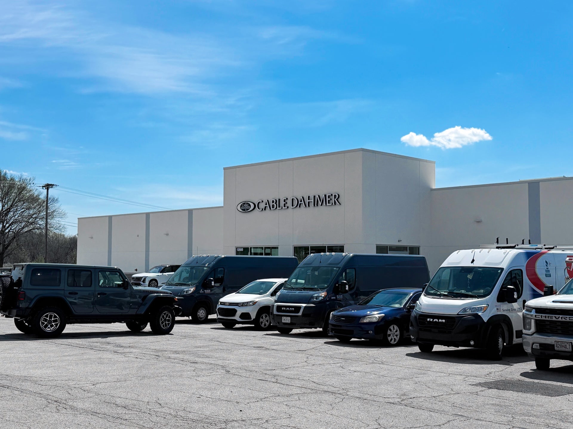 Commercial work trucks and fleet vehicles parked outside the Cable Dahmer Fleet & Commercial Service Center